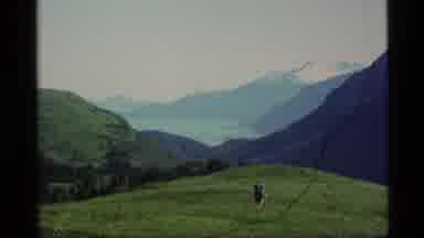 Alaska USA (1977): Backpacker Crossing Grassy Plateau Mountain Range In Background