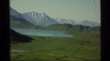 Alaska USA (1977): A Lake In A Field With Mountains In The Background That Have