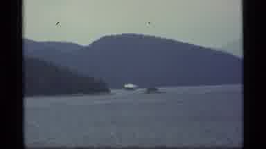 Alaska USA (1977): Boat Cruising A Lake To Get Away While A Helicopter Hovers