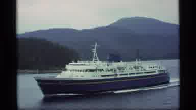 Alaska USA (1977): Blue Boat Cruising Down Serene Lake Towards Mountain Range