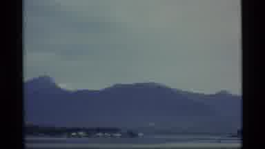 Alaska USA (1977): Looking At A Foggy Mountain Range Above A Body Of Water With