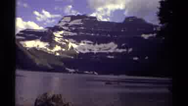 Canada (1979): A Lake With A Boat On It And Mountains In The Background With A