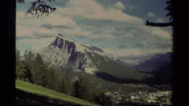 Canada (1979): View Of Snow Covered Mountain Slope And Green Fields On A Bright