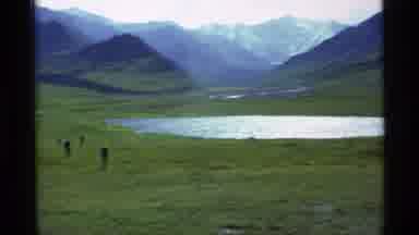 Alaska USA (1977): Pan Across Meadow With Lake And Mountains With Sharp Cut To