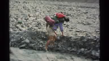Alaska USA (1977): A Man Hiking With A Giant Backpack Over A Creek