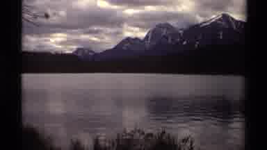Canada (1979): A Large Body Of Water Surrounded By Pine Trees And Mountains