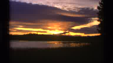 Alaska USA (1977): A Golden Sunset In A Cloudy Sky Overlooking A Lake With Dark