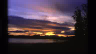 Alaska USA (1977): Purple And Gold Sunset Over A Lake Surrounded By Trees