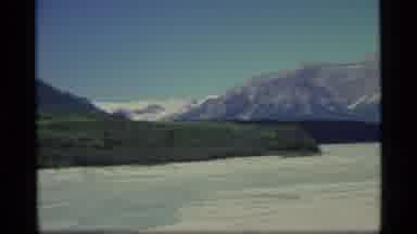 Alaska USA (1977): Aerial View Of Frozen Lake Trees And Mountain On A Clear Sunny