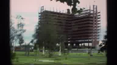 Alaska USA (1977): New High Rise Building Being Built Next To Small Cabin