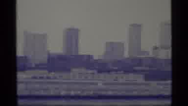 Alaska USA (1977): View Over A City With Skyscrapers And A River Flowing Through