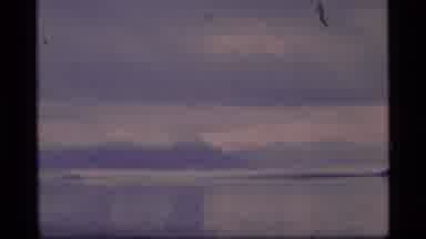 Alaska USA (1977): People Resting On The Shore Of A Lake In Winter With Snow In