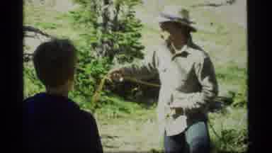 Sapphire Lake Montana USA (1977): Man With Glasses And Hat Is Explain To A Kid How