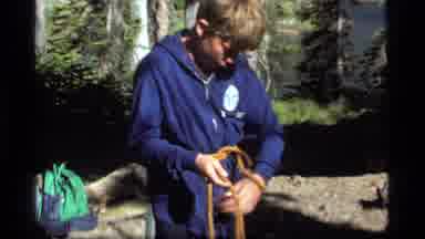 Sapphire Lake Montana USA (1977): Young Boy In Blue Jacket Tying A Rope While