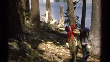 Lake Tahoe California USA (1978): Hikers Walking Along Riverbank Carrying Camping