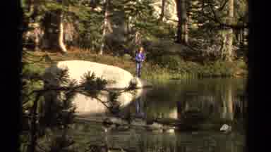 Lake Tahoe California USA (1978): Person Standing On Rock Beside Stream Throwing