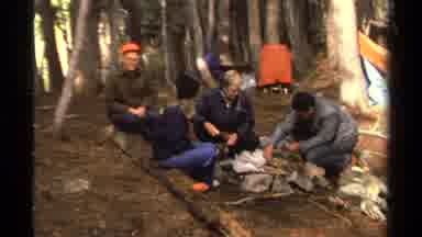 Lake Tahoe California USA (1978): Four Campers Sitting And Talking As One Prepares