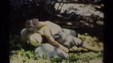 Lake Tahoe California USA (1978): Woman Rests Beside Rock On Backpack In Shade Of