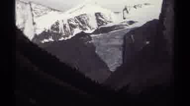 British Columbia Canada (1979): Camera Zooms In On Tall Gray Snow Capped Mountains