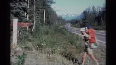 Alaska USA (1977): Small Group Of People Hiking Cross The Road While Carrying