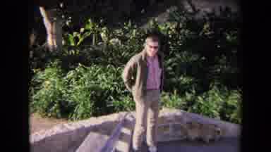 Los Angeles California USA (1967): Man Walking His Dog Near A Parking Lot With A