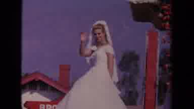 Los Angeles California USA (1967): A Woman Wearing A White Dress Waves As She