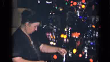 Sebring Ohio USA (1942): Woman With Bun Hangs Silver Tinsel On Christmas Tree With