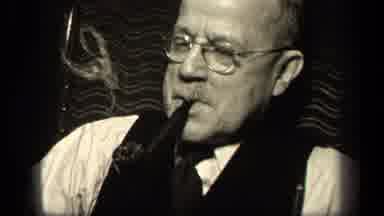Sebring Ohio USA (1942): A Older Man With Glasses Smoking A Pipe In A Room With
