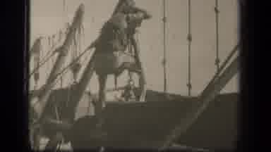 LEYTE GULF PHILIPPINES-1944: Sailor Climbing Rigging On Docked Sailboat