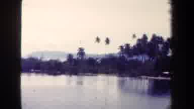 Papua New Guinea (1944): Body Of Water Lined With Trees And A Mountain In The