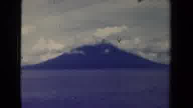 Papua New Guinea (1944): Old Footage Of Grassy Field With Mountain Behind Clouds