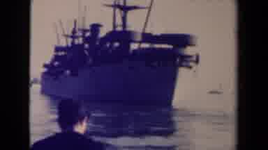 FRANCE-1945: Man Watches Naval Vessel Anchored Near Shore