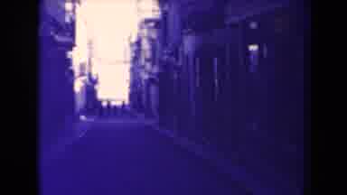 France (1945): Person Wearing Black Walking Down Empty Street On A Sunny Day