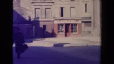France (1945): Man Walks Slowly On Street Next To Large Government Building