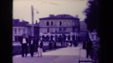 France (1945): Small Group Of People Walk By A Historic Looking Building