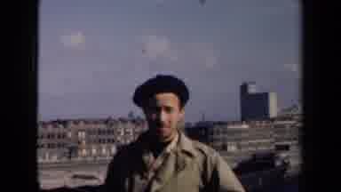 NETHERLANDS-1946: Man Speaks To The Camera In Front Of City Buildings