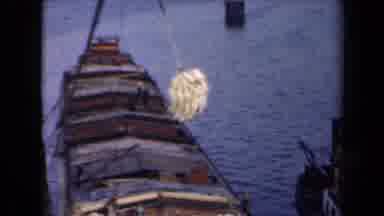 Netherlands (1946): Yellow Items Are Being Loaded Onto A Ship On The Water