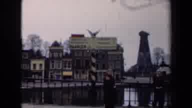 Netherlands (1946): Person Standing Near A Sign And Railing By A River In A Town