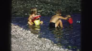 Kansas City Missouri (1959): Two Young Children Playing In The Water On A Rocky