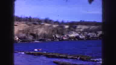 Kansas City Missouri (1959): Short Rocky Coastline Behind Blue Water And An Adult