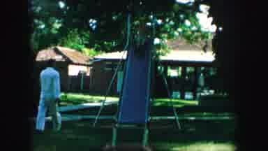Kansas City Missouri (1959): Shirtless Male Child Sliding Down Slide In Backyard