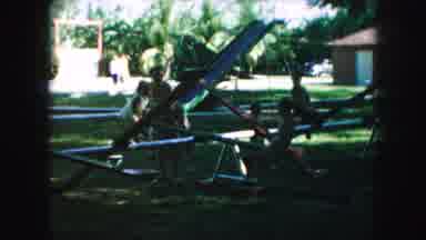 Kansas City Missouri (1959): Children Playing On Teeter Totter At Park While Mom
