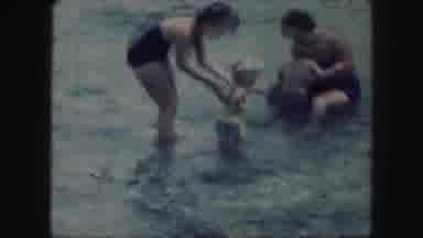 KANSAS CITY MISSOURI-1959: Two Women Playing In The Ocean With Their Children