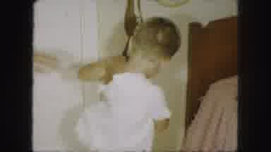 Kansas City Missouri (1959): A Young Son Gets Dressed With His Mother's Assistance