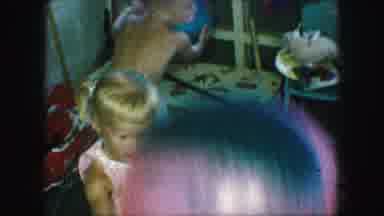 Kansas City Missouri (1959): Mother Relaxing While Children Play With Balls