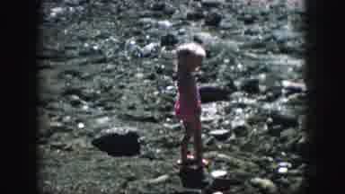 KANSAS CITY MISSOURI-1959: Two Children Explore Rocky Shoreline