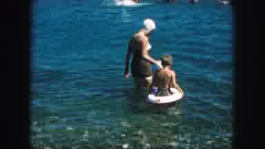 KANSAS CITY MISSOURI-1959: Mother Takes Her Two Children Out Into The Ocean With