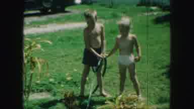 Kansas City Missouri (1959): Young Boy And Girl Use Garden Hose To Water Yard