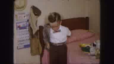 Kansas City Missouri (1959): Boy Puts On A Jacket Next To Pink Bed With Easter