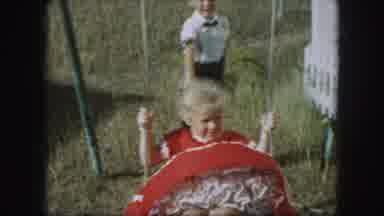 Kansas City Missouri (1959): Girl Wearing Red Dress Pushed On Swing By Boy Wearing